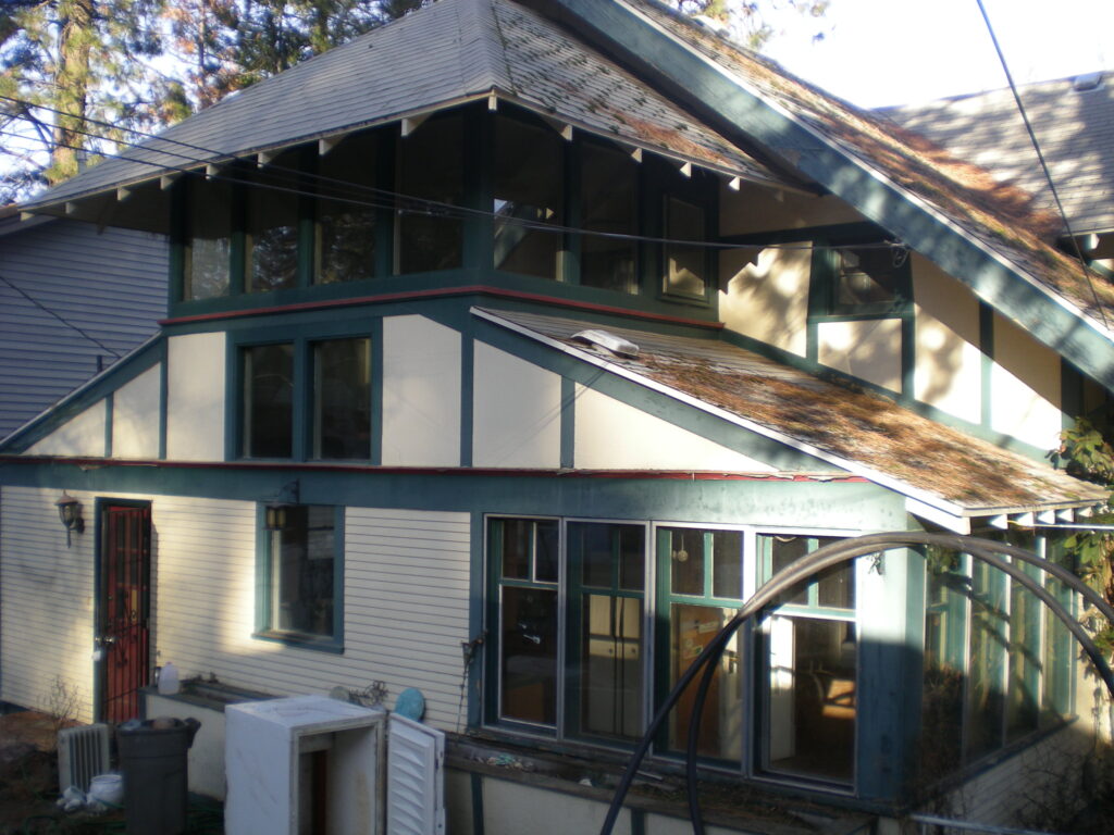 back of white green and red trimmed house